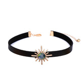 Elegant black choker adorned with a sunburst stone, made of crystal and cubic zirconia, finished in 18k gold plating.
